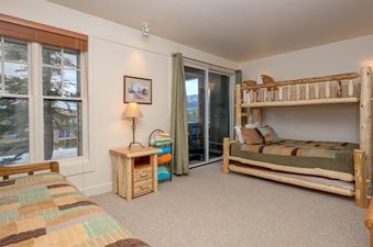 The bedroom at Moonlight Basin Saddle Ridge B5 features a bunk bed and a view of the mountains.
