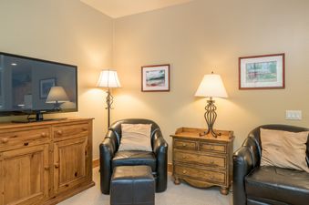 A living room with two leather armchairs and a television.