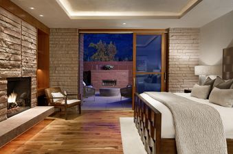 Luxurious bedroom with fireplace and outdoor access.
