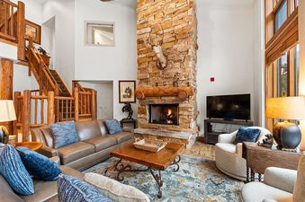 The living room in Timbers 3082 features a stone fireplace and comfortable seating.