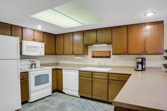 The kitchen at Park Station 122 features white appliances and wood cabinets.