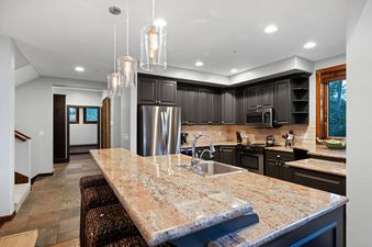Modern kitchen with granite countertops, dark gray cabinetry, and stainless steel appliances in Deer Valley Double Eagle.