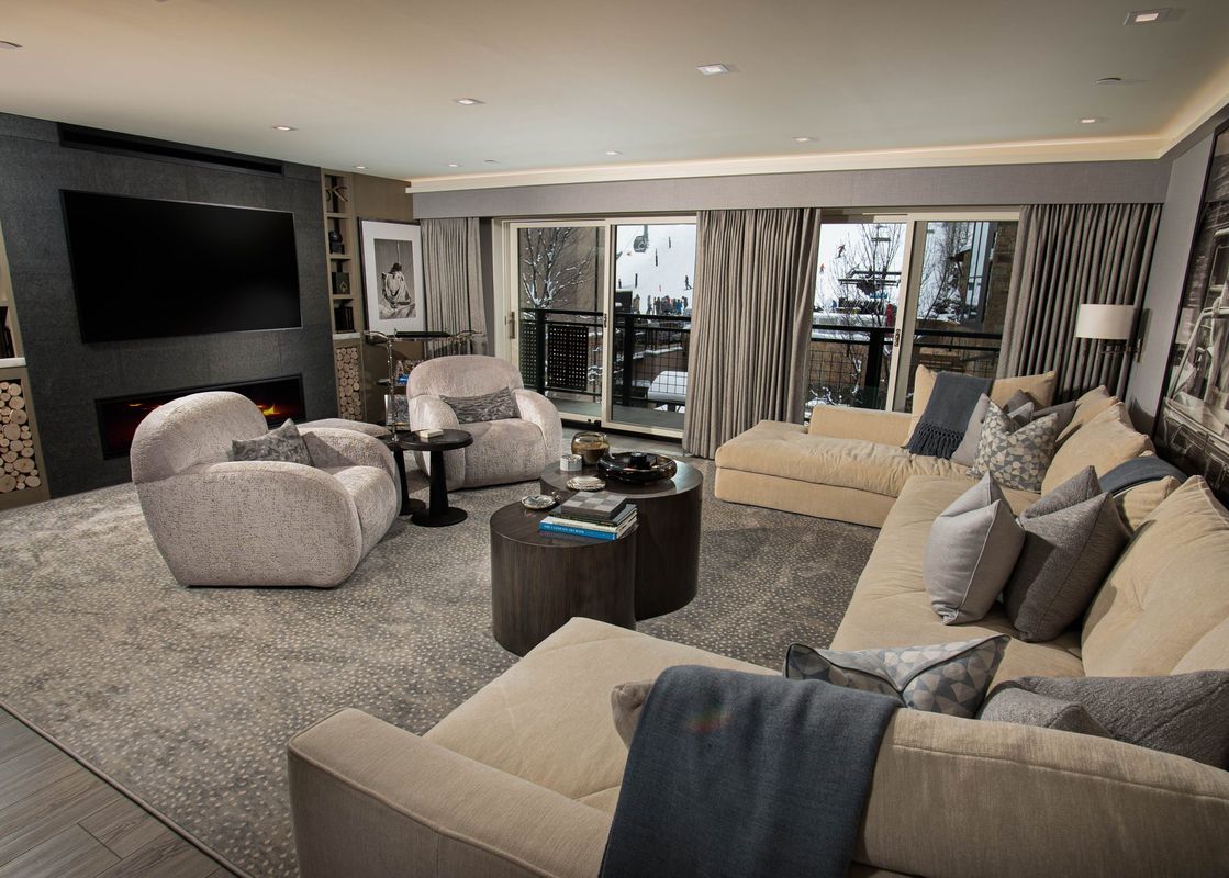 The Clubhouse features a spacious living room with a cozy fireplace, a large sectional sofa, and views of the surrounding mountains.