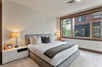 The primary bedroom in Silver Strike Lodge 407 features a bed with nightstands and lamps, and a window.