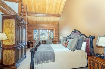 A cozy bedroom with wooden ceiling and logs at Townhomes On The Creek 121.