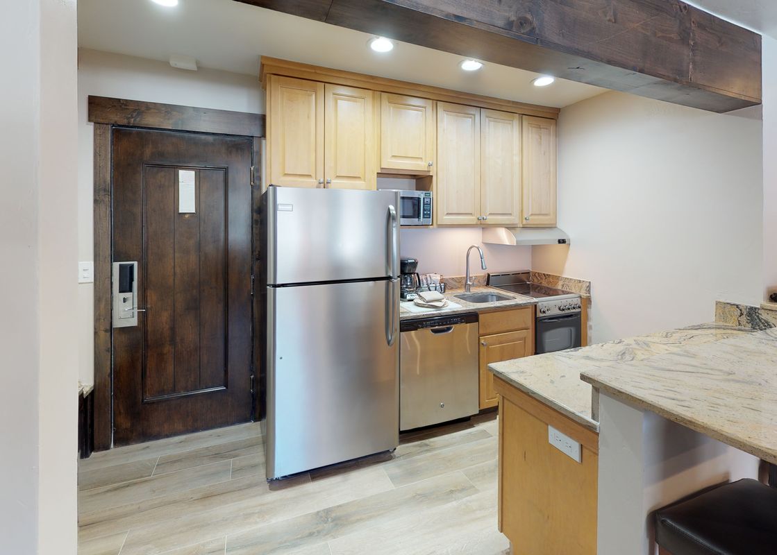 The kitchen in Manor Vail 163 has stainless steel appliances, a granite countertop, and a breakfast bar.
