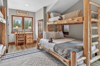 A cozy bedroom with wooden bunk beds and a desk, offering a warm and inviting atmosphere.