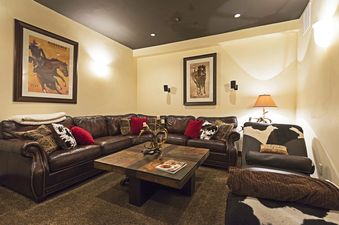 Cozy living area in Big Game Lodge Park City with leather sectional and rustic decor.