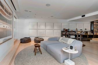Modern lounge with a plush sectional sofa, a textured rug, and framed art at The Pinnacle at Powder Ridge.