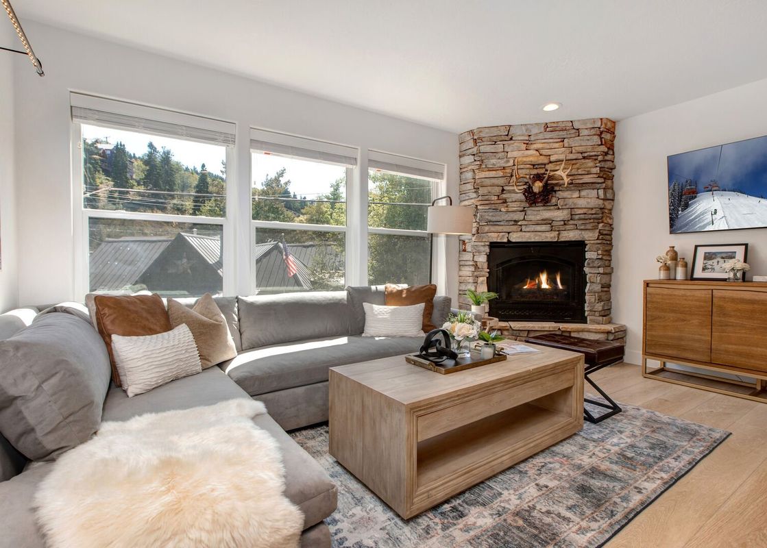 Living room at Abode at Kings Gold featuring a corner fireplace, couch and view of the outdoors.