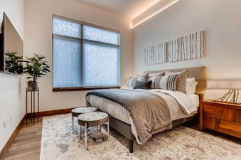 Stylish bedroom in Riverfront Townhome 13 with a large window.