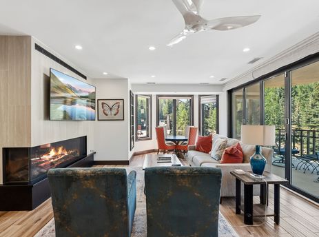 A modern and cozy living area at 421 Beaver Creek Lodge featuring a sleek fireplace, comfortable seating, and scenic views through large windows.