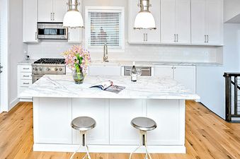 Boulders Way 126 kitchen with white cabinets, marble countertops, and stainless steel appliances.