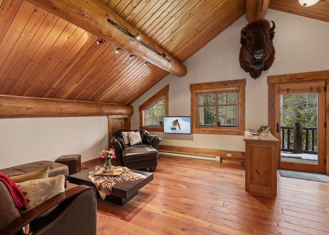 Cozy wood-paneled living area at Forest Edge with leather furniture and rustic details.