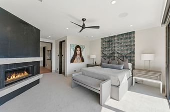 A master bedroom at Star Gazer at Deer Valley featuring a large bed, fireplace, and a striking painting.