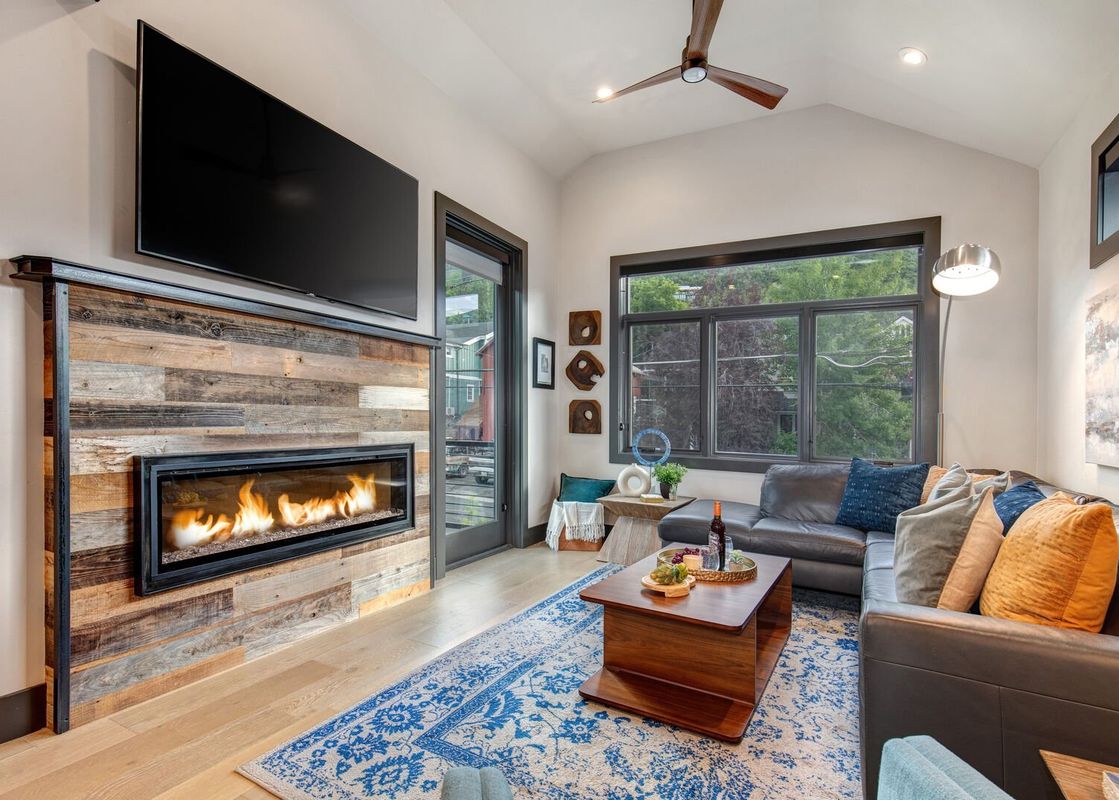 A modern living room with a fireplace, a sectional sofa, and a coffee table.