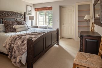 A cozy bedroom at Crail Creek 85 with a large bed, dark wood furniture, and a window view.