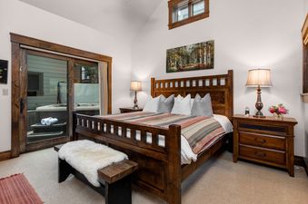 The bedroom in Abode at Town Lift features a king bed and access to the outdoor hot tub.