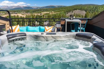 A close-up view of the hot tub with stunning mountain views, inviting guests to relax and soak in the serene surroundings.