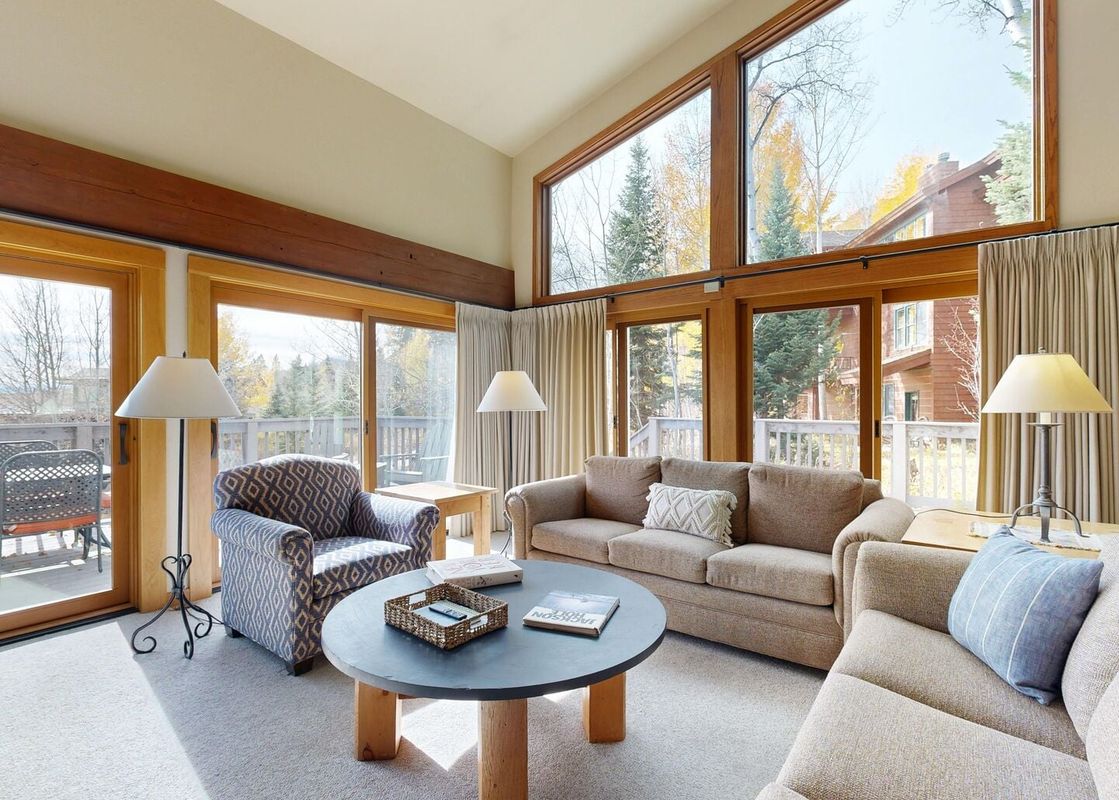 Comfortable living room in Timber Ridge 1 with vaulted ceilings, large windows, and cozy seating.