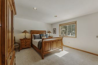 The beautifully decorated bedroom features warm wood furniture and a cozy ambiance.