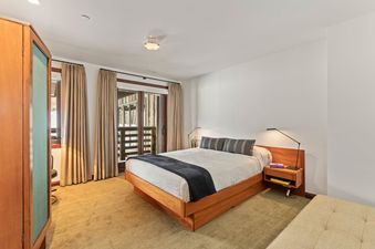 The bedroom in Abode on the Big Trail features a plush bed and balcony access.