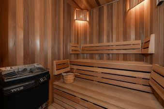 A cozy, well-lit wooden sauna with benches and a heater.