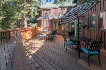 An outdoor deck with tables and chairs offers a relaxing space at Manitou Lodge 9.