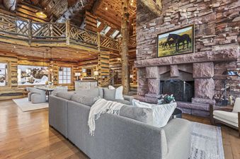 The Treehouse in Canyons Village features a large sectional couch, a stone fireplace and a spacious open floor plan.