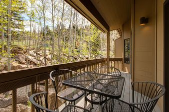 A furnished balcony offers a relaxing outdoor space at Abode on Doe Pass.