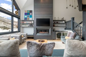 The living room at Stone Creek Chalet at The Aspens boasts a fireplace and comfortable seating.