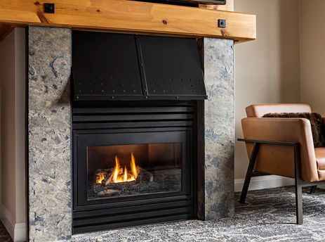 A close-up view of the fireplace at The Westin Resort Deluxe Studio Suite with 2 Queen Beds, showcasing the stone surround and a warm fire.