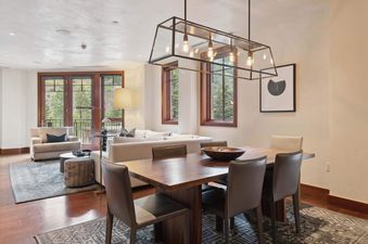 A spacious open-concept living and dining area in Solaris 4EE with modern furnishings and large windows overlooking lush greenery.