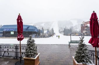 The Eagle Bahn Gondola 19 is visible in the distance, surrounded by snow and evergreens, with a building that resembles a ski resort lodge to the right.