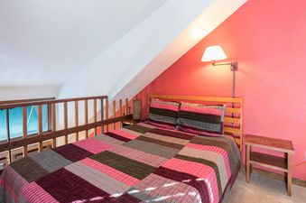 A cozy bedroom in Manitou Lodge 11 features a quilt-covered bed and a warm, inviting atmosphere.