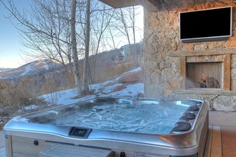 Relax in the hot tub at Dreamscape 365 while enjoying mountain views.