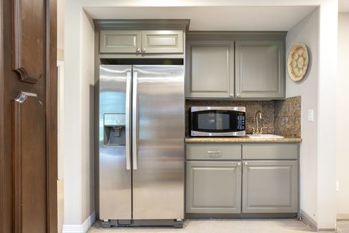 A view game room wet bar at 11A Castle Peak Close, featuring stainless steel appliances and custom cabinetry.