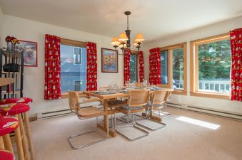 A dining table with woven chairs and a chandelier in Rendezvous A2.