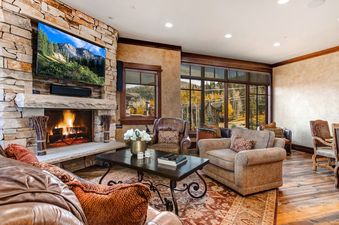Silver Summit living room with a fireplace, a large TV, and a view of the mountains.