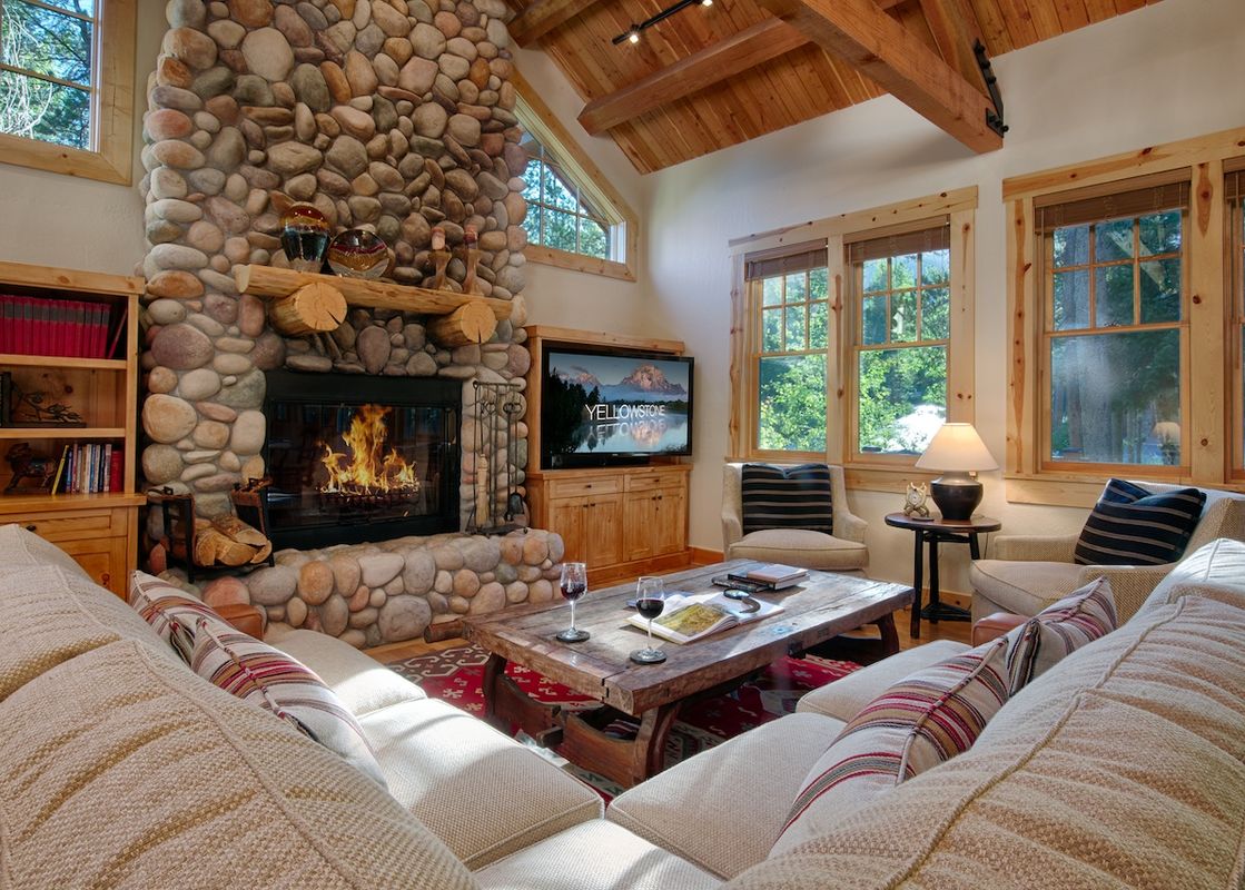 Cozy living room with a stone fireplace and vaulted wood ceilings at Granite Ridge Homestead 3072.