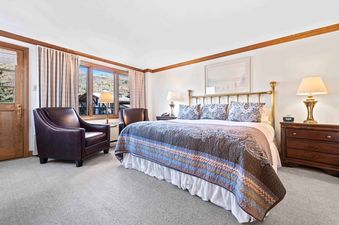 Lodge Tower 378 bedroom featuring a king bed with bedside tables and two leather armchairs.