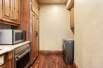 Grand Lodge Studio 204 has a full-sized washer and dryer in a utility closet with wood cabinets.