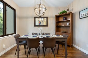 A dining table set in a well-lit room with hardwood floors.