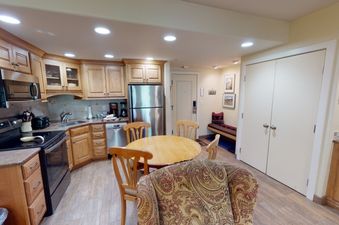 The kitchen in Manor Vail 081 features stainless steel appliances, ample cabinet space, and a dining area with a table and chairs.