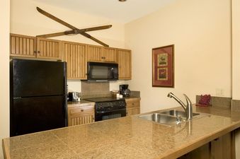 Kitchen of Mountain Thunder 2 Bedroom Condo with a granite breakfast bar and black appliances.