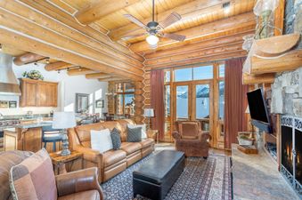 The living area at Villas At Tristant 221 features beautiful log walls and a stone fireplace.