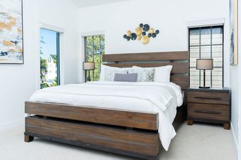 The bedroom at Apres Chalet Winter Park features a wooden bed, white bedding, and two nightstands with lamps.