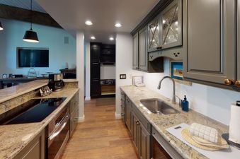 A kitchen with granite countertops, stainless steel appliances, and a double-basin sink.