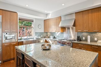 Modern kitchen with granite countertops, wood cabinets, and stainless-steel appliances at Fitzsimmons Walk 39.