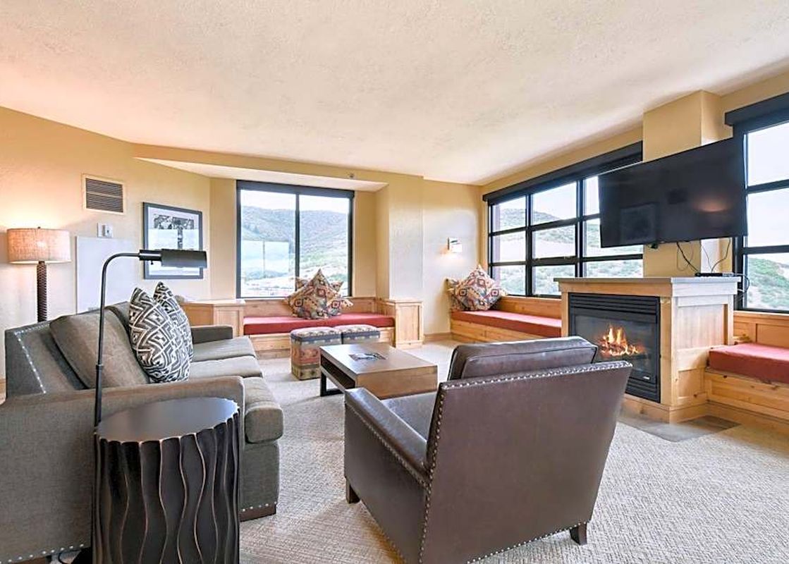 The living room at The Grand Summit Lodge Studio Residence features cozy seating and a fireplace.